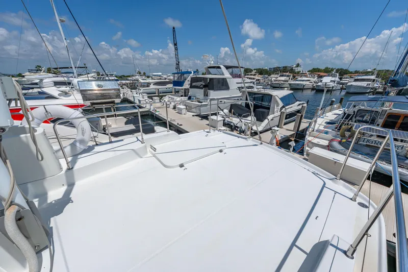 Slide: The Image of 2006 Beneteau Swift Trawler 42 docked at a marina under a clear blue sky. - 49