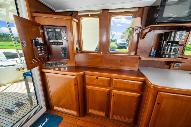Slide: The Image of Interior of 2006 Beneteau Swift Trawler 42 with wooden cabinetry and control panel. - 64
