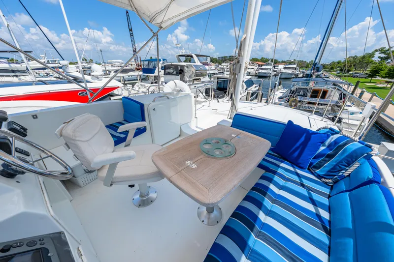 Slide: The Image of 2006 Beneteau Swift Trawler 42 flybridge with striped seating and helm, docked at marina. - 59