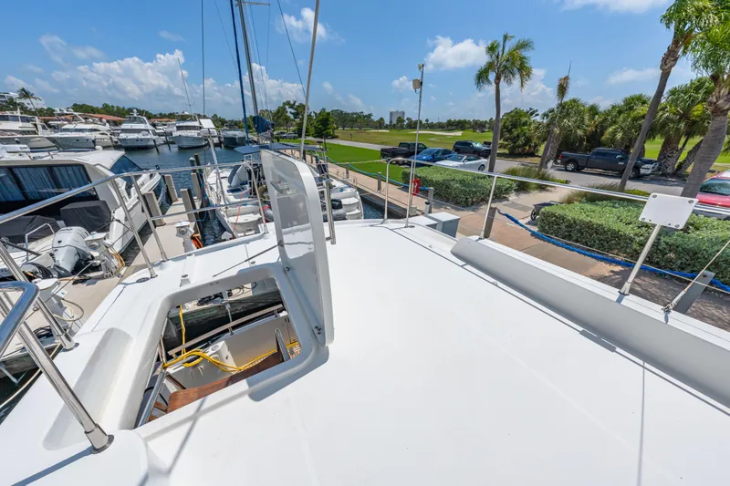 Slide: The Image of 2006 Beneteau Swift Trawler 42 docked at marina, sunny day, palm trees in background. - 48