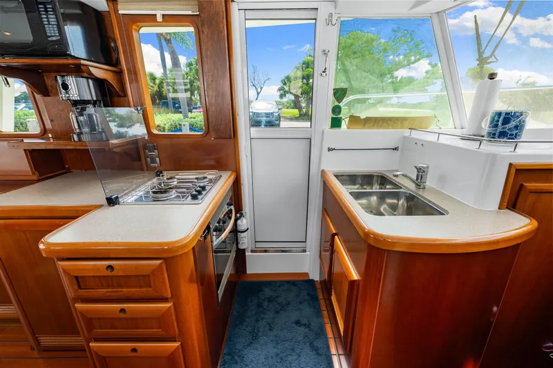 Slide: The Image of 2006 Beneteau Swift Trawler 42 kitchen with stove, sink, and wooden cabinetry. - 66