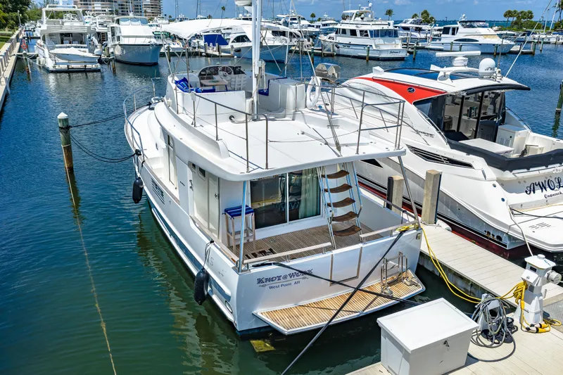 Slide: The Image of 2006 Beneteau Swift Trawler 42 docked at marina, surrounded by other boats. - 14