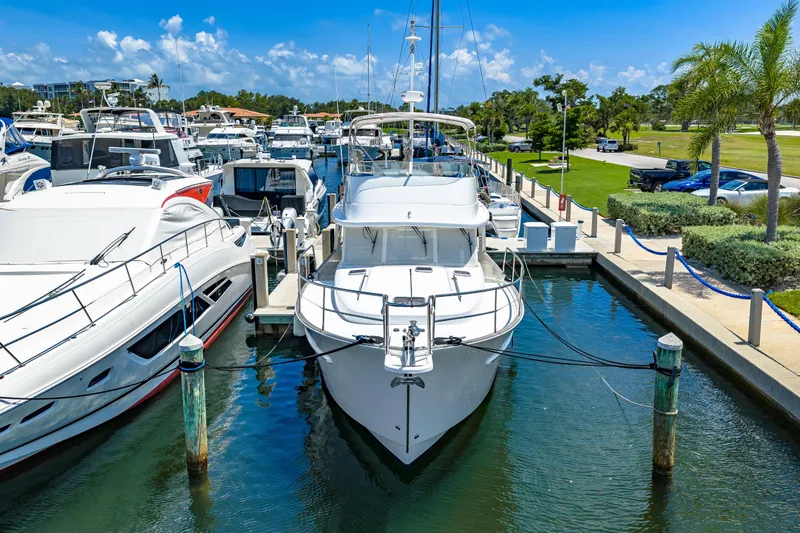 Slide: The Image of 2006 Beneteau Swift Trawler 42 docked at a marina, surrounded by other boats. - 6