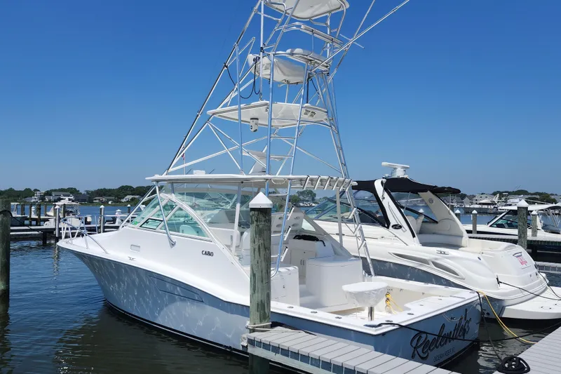 Slide: The Image of 2009 Cabo 36 Express boat docked at marina under clear blue sky. - 3