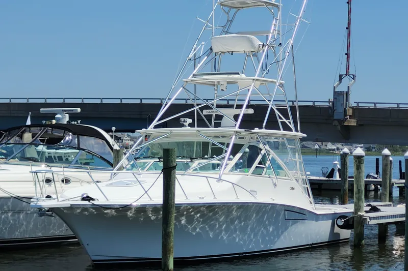The Image of 2009 Cabo 36 Express boat docked at marina under clear blue sky. - 0