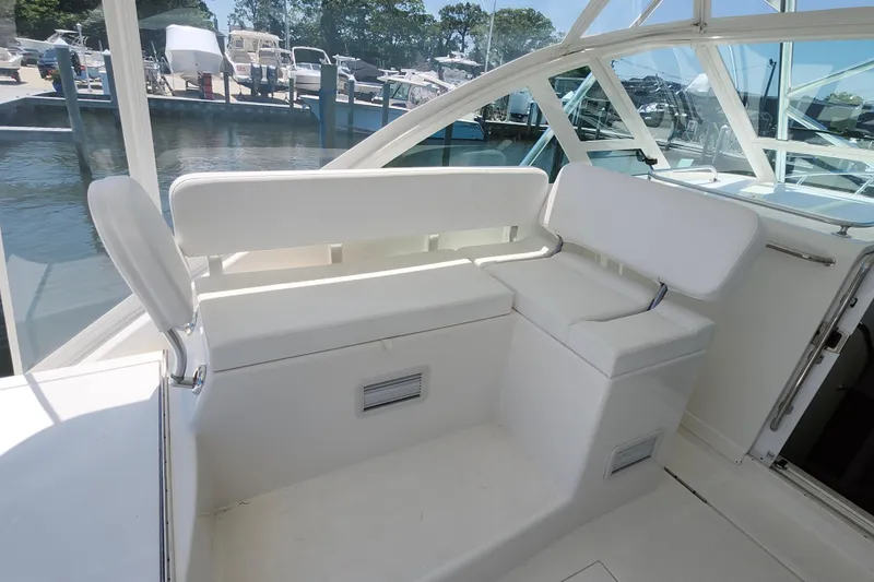 Slide: The Image of 2009 Cabo 36 Express boat interior with white seating and marina view. - 11