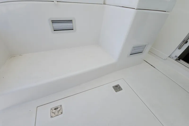 Slide: The Image of 2009 Cabo 36 Express boat interior, featuring white seating and storage compartments. - 24