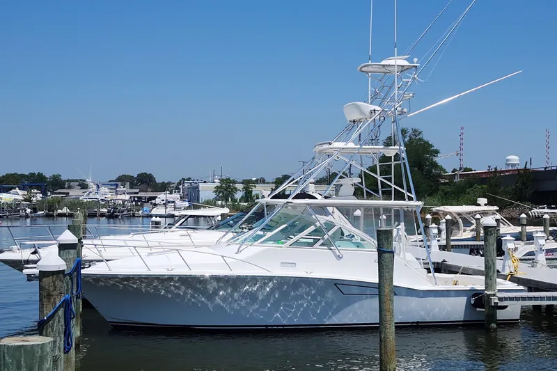Slide: The Image of 2009 Cabo 36 Express yacht docked at marina under clear blue sky. - 2