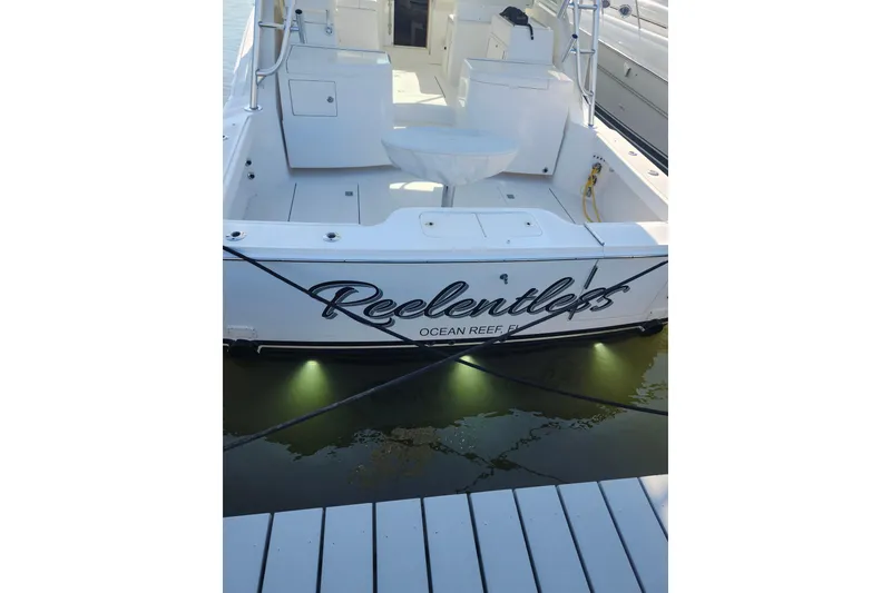 Slide: The Image of 2009 Cabo 36 Express boat docked, rear view with "Reelentless" name visible. - 28