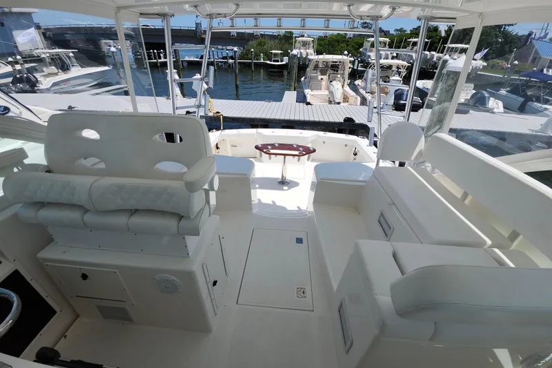 Slide: The Image of 2009 Cabo 36 Express boat interior with white seating and marina view. - 16