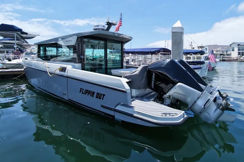 Slide: The Image of 2024 Saxdor 320 GTC boat docked in marina, featuring sleek design and powerful outboard motor. - 3