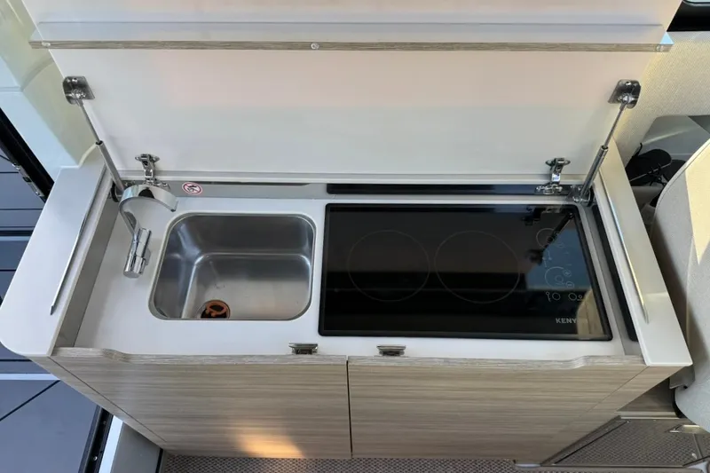 Slide: The Image of 2024 Saxdor 320 GTC kitchenette with sink and electric stove, featuring modern design. - 32