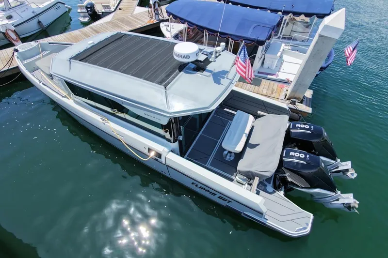 Slide: The Image of 2024 Saxdor 320 GTC boat docked, featuring sleek design and dual outboard motors. - 5