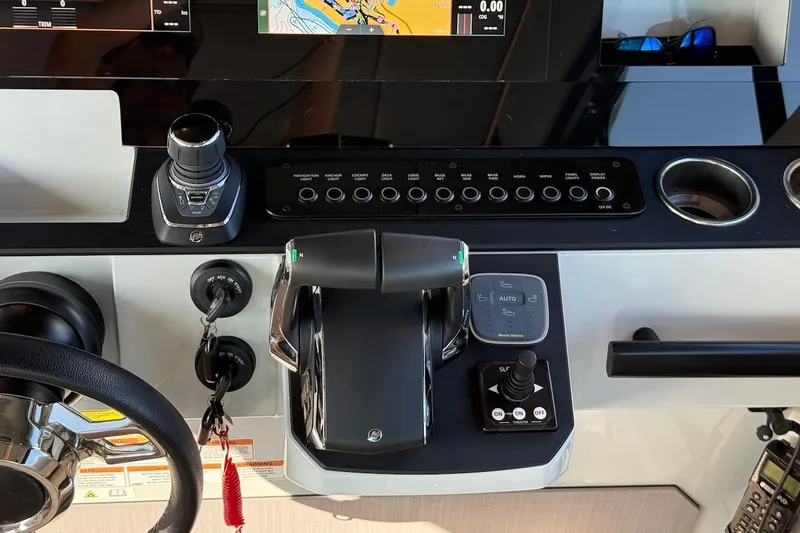 Slide: The Image of Cockpit controls of 2024 Saxdor 320 GTC boat with steering wheel and navigation system. - 27