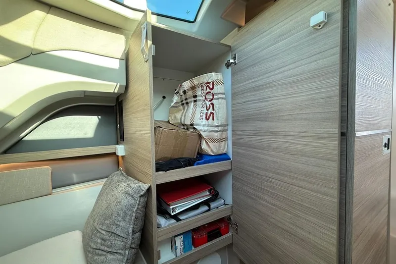Slide: The Image of Interior storage of 2024 Saxdor 320 GTC boat with open wooden cabinet and shelves. - 43