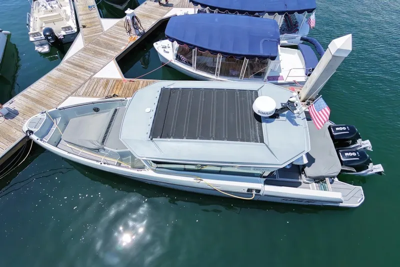 Slide: The Image of 2024 Saxdor 320 GTC boat docked at marina with twin engines and American flag. - 4