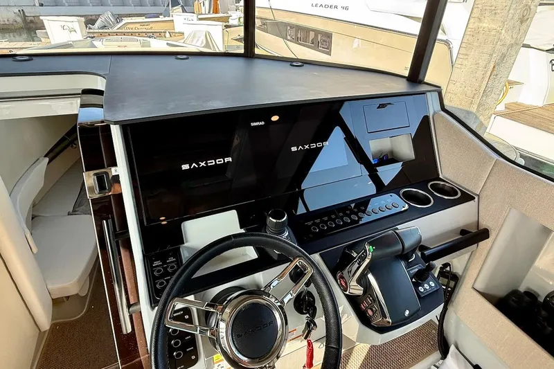 Slide: The Image of 2024 Saxdor 320 GTC boat cockpit with modern steering and control panel. - 24