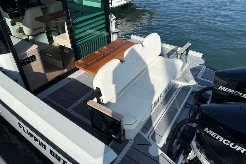 Slide: The Image of 2024 Saxdor 320 GTC boat with seating area and twin Mercury engines on water. - 9