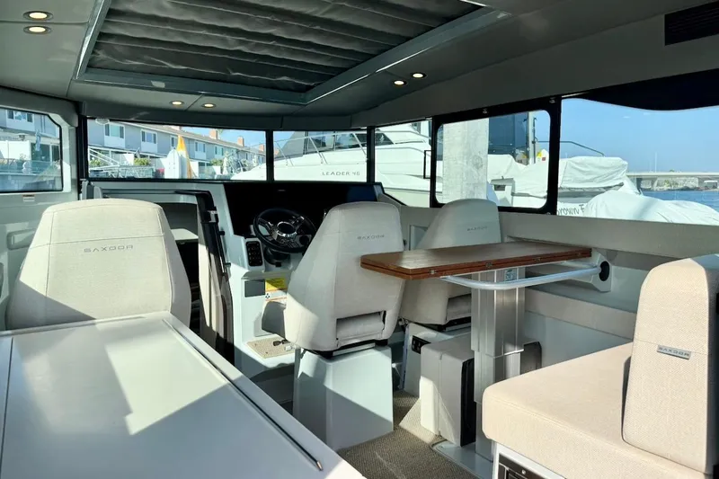 Slide: The Image of Interior of 2024 Saxdor 320 GTC boat, featuring modern seating and steering area. - 16