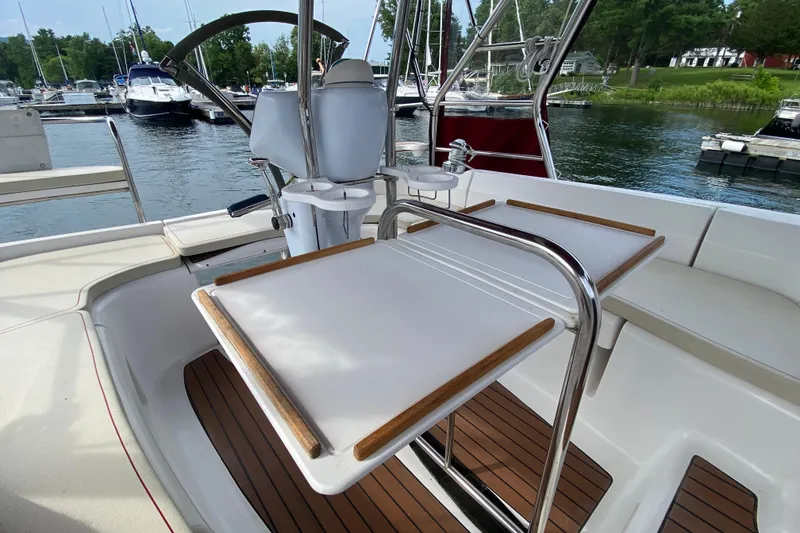 Slide: The Image of Cockpit of 2005 Hunter 38 sailboat with folding table and steering wheel, docked at marina. - 15