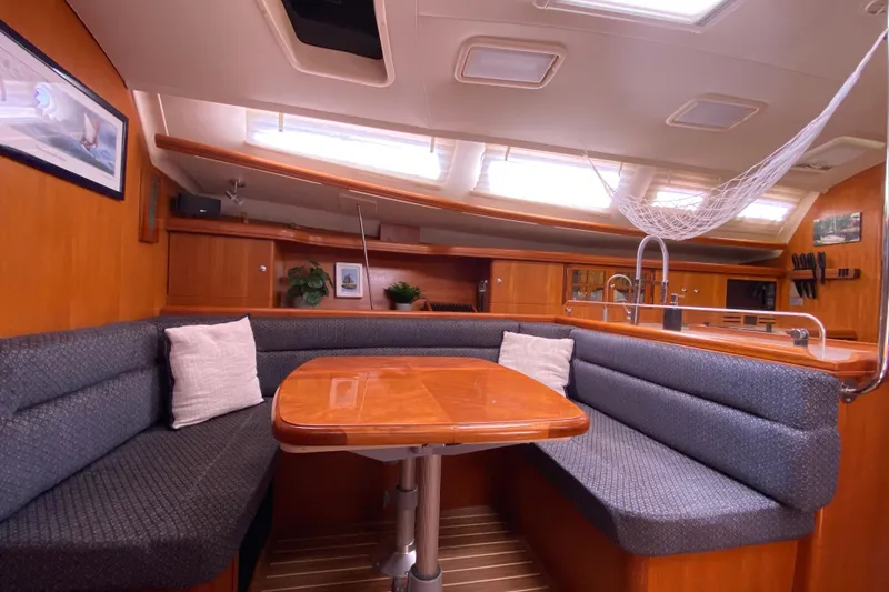 Slide: The Image of Interior of a 2005 Hunter 38 sailboat with cozy seating and wooden table. - 22