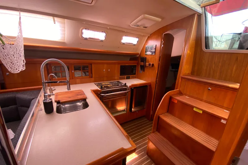 Slide: The Image of Interior of 2005 Hunter 38 sailboat with modern kitchen and wooden cabinetry. - 17
