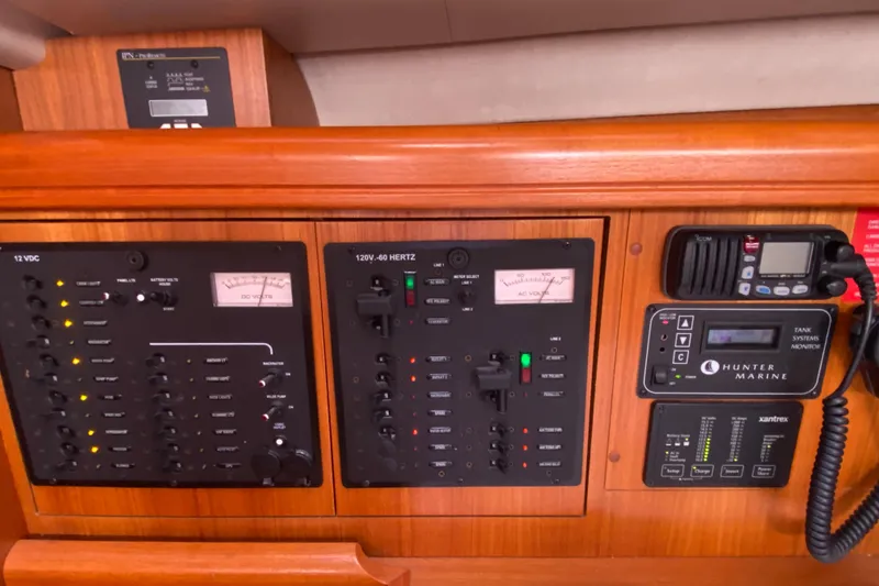 Slide: The Image of Electrical control panel on a 2005 Hunter 38 yacht, featuring various switches and meters. - 26