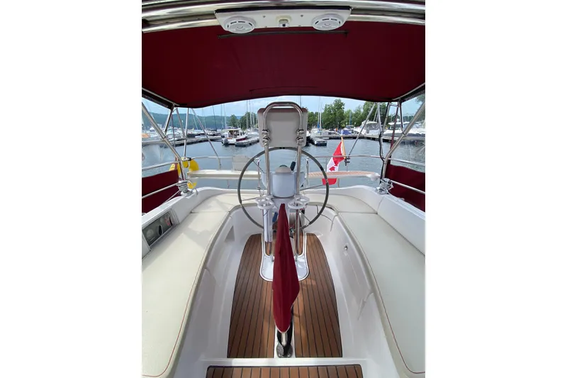 Slide: The Image of Cockpit of 2005 Hunter 38 sailboat with red canopy and wooden deck. - 13