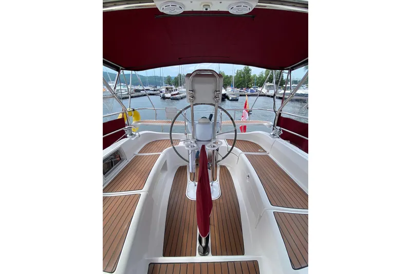 Slide: The Image of Cockpit of 2005 Hunter 38 sailboat with wooden deck and red canopy at marina. - 12