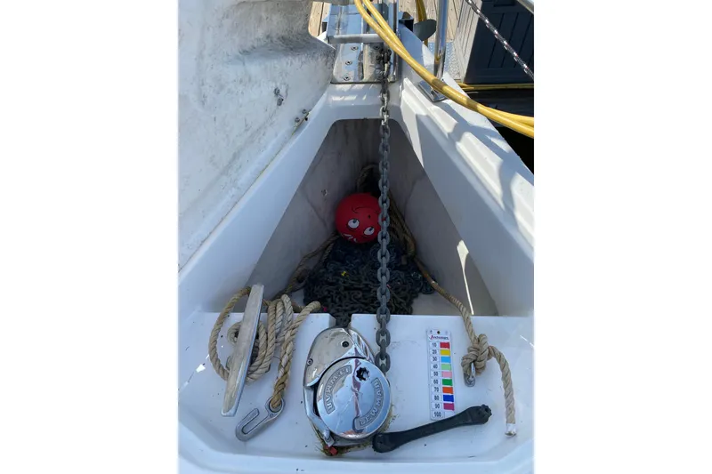 Slide: The Image of Anchor chain and winch on 2005 Hunter 38 sailboat deck, with ropes and red buoy. - 11