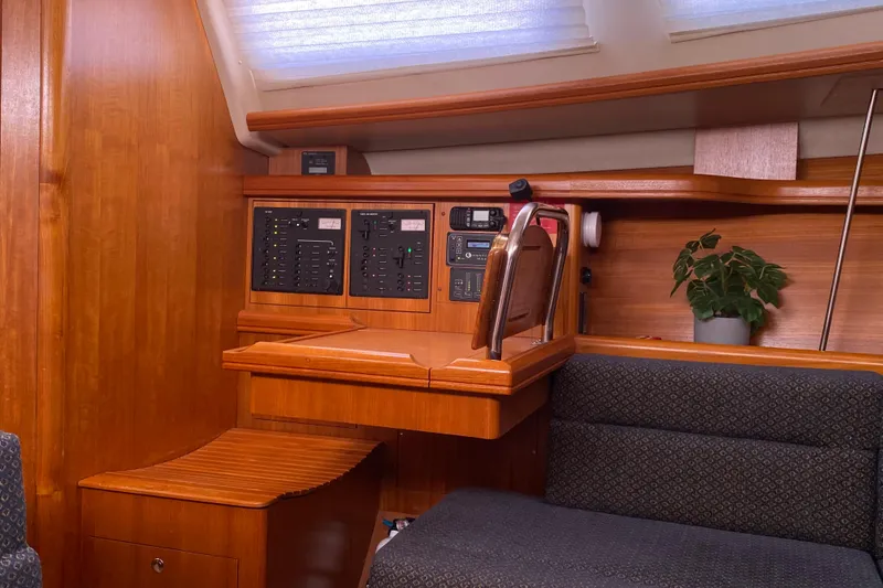Slide: The Image of Interior of a 2005 Hunter 38 sailboat with navigation panel and seating area. - 24