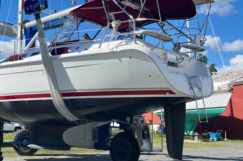 Slide: The Image of 2005 Hunter 38 sailboat on a lift, showcasing its hull and keel. - 31