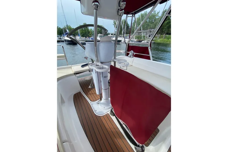 Slide: The Image of Cockpit of 2005 Hunter 38 sailboat with red canvas and wooden flooring. - 14