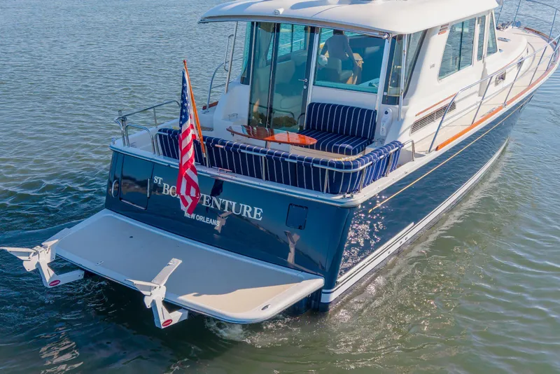 Slide: The Image of 2016 Sabre 48 Salon Express yacht on water, rear view with American flag. - 3