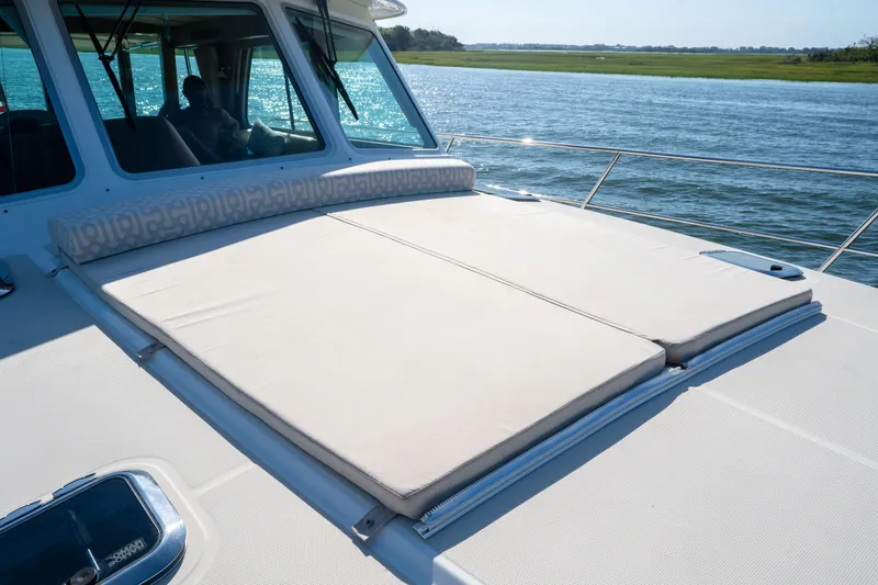 Slide: The Image of 2016 Sabre 48 Salon Express yacht with sunpad, cruising on serene waters. - 14