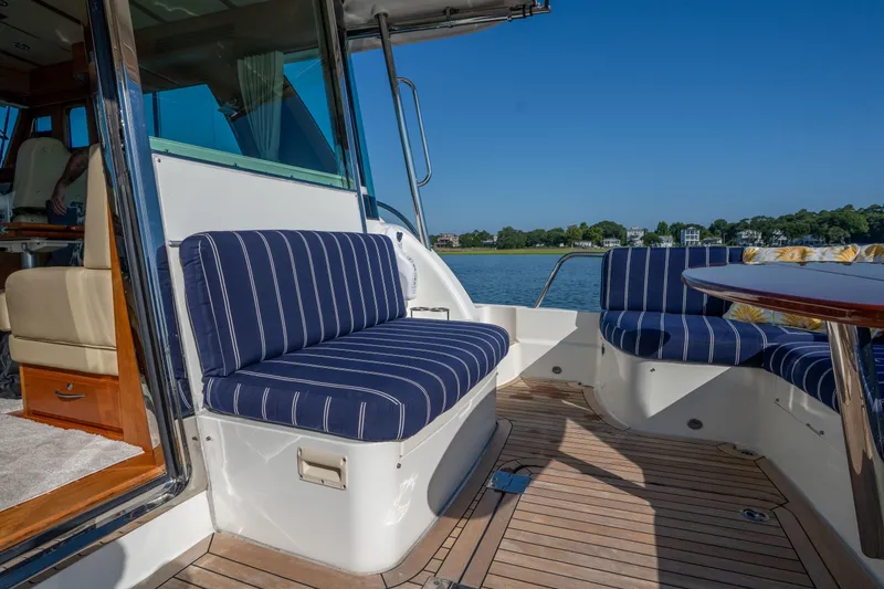 Slide: The Image of 2016 Sabre 48 Salon Express yacht with striped seating and scenic waterfront view. - 9