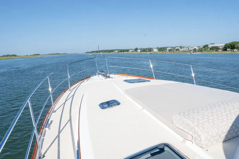 Slide: The Image of 2016 Sabre 48 Salon Express yacht cruising on a serene waterway under clear blue skies. - 17