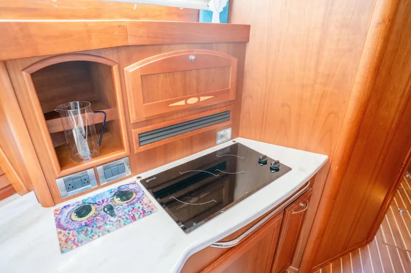 Slide: The Image of Luxurious 2016 Sabre 48 Salon Express yacht kitchen with wooden cabinetry and modern stovetop. - 30