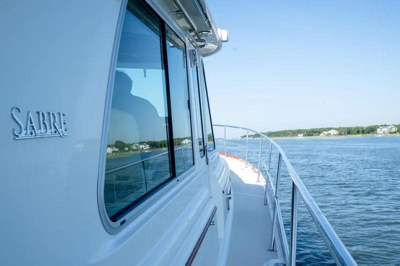Slide: The Image of 2016 Sabre 48 Salon Express yacht cruising on a serene waterway. - 12