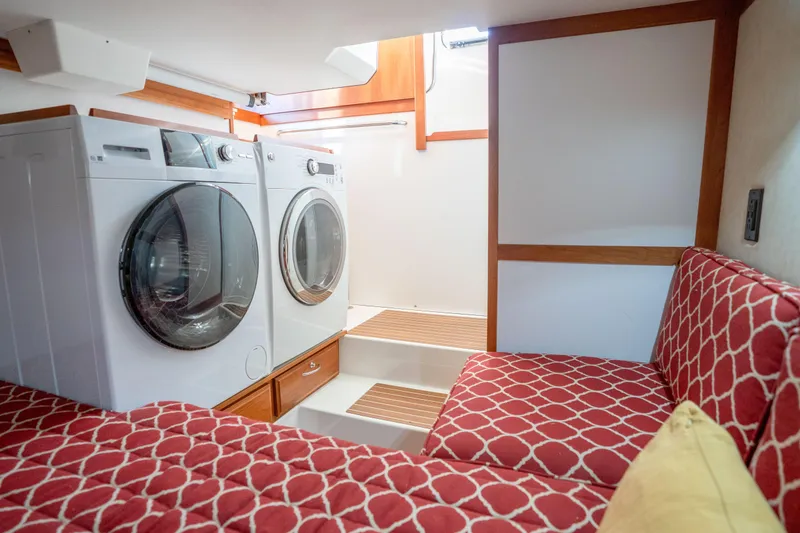 Slide: The Image of Laundry area with washer, dryer, and seating in 2016 Sabre 48 Salon Express yacht. - 43