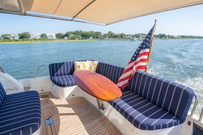 Slide: The Image of 2016 Sabre 48 Salon Express yacht with striped seating and American flag on deck. - 10