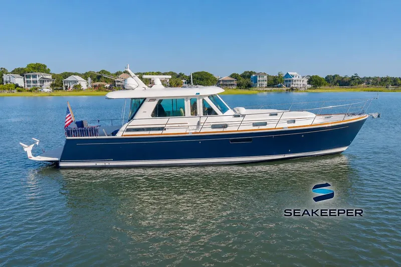 The Image of 2016 Sabre 48 Salon Express yacht on calm water, featuring sleek design and American flag. - 0