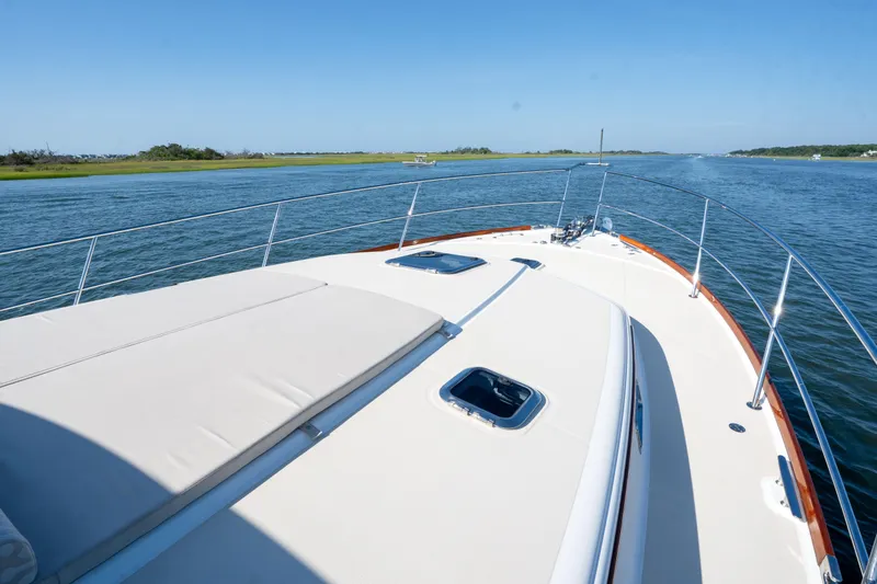 Slide: The Image of 2016 Sabre 48 Salon Express yacht cruising on a serene waterway under a clear blue sky. - 13