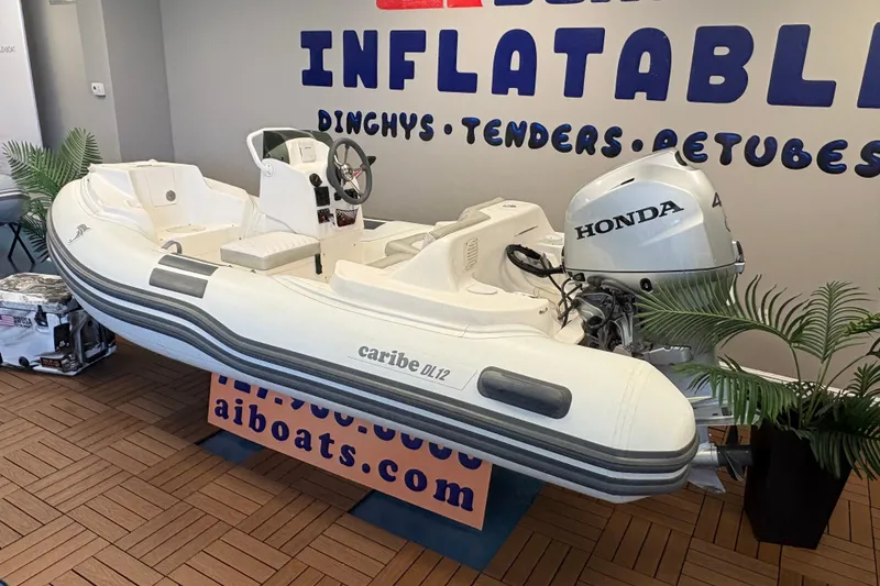 Slide: The Image of 2019 Caribe DL12 inflatable boat with Honda motor displayed indoors. - 3