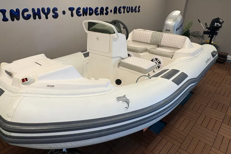 Slide: The Image of 2019 Caribe DL12 inflatable boat with seating, displayed indoors on wooden flooring. - 5