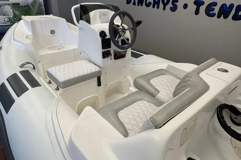 Slide: The Image of 2019 Caribe DL12 inflatable boat interior with white quilted seating and steering console. - 6