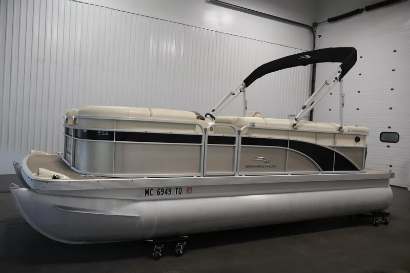 Slide: The Image of 2013 Bennington 20 SLMX pontoon boat in a showroom with a black canopy. - 7