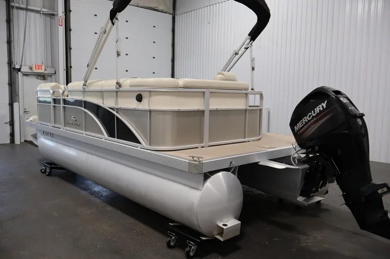 Slide: The Image of 2013 Bennington 20 SLMX pontoon boat with Mercury outboard motor in a garage setting. - 6