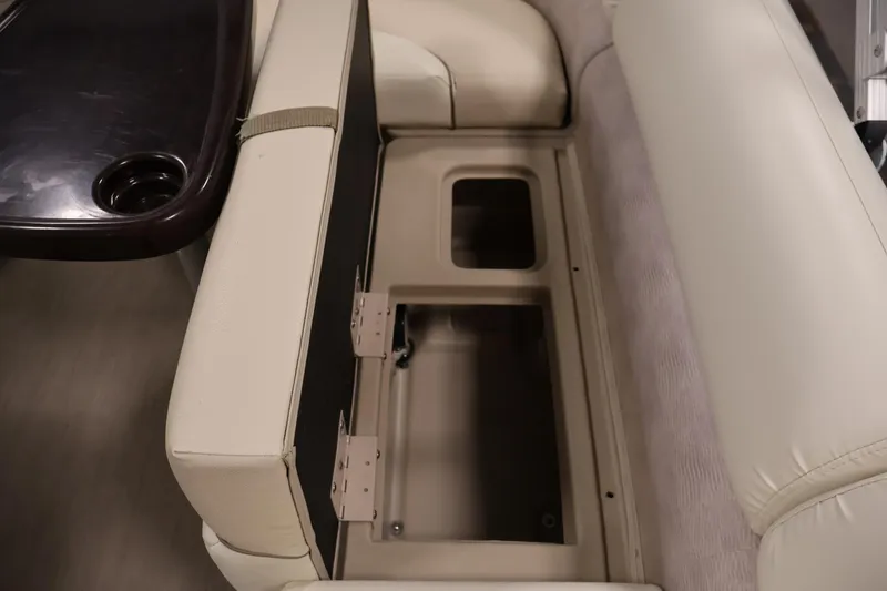 Slide: The Image of 2013 Bennington 20 SLMX boat interior with open storage compartment and cup holder. - 28