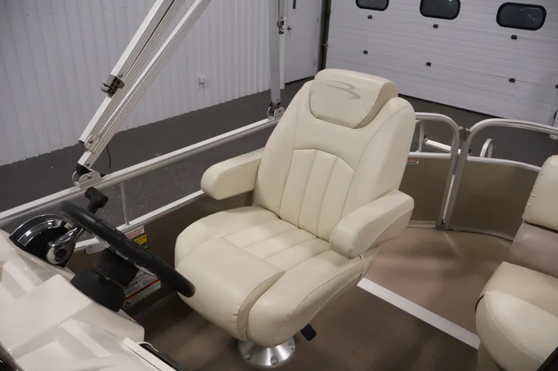 Slide: The Image of 2013 Bennington 20 SLMX boat interior with beige captain's chair and steering console. - 26